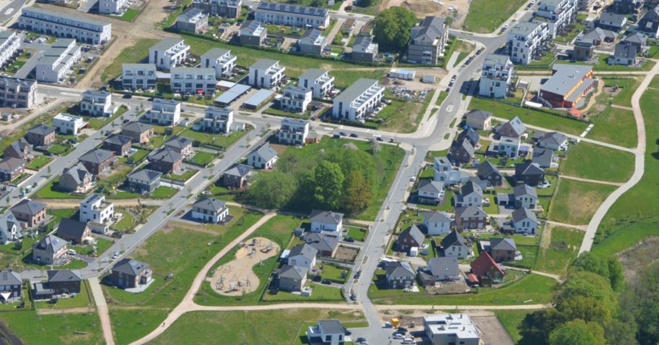 Luftbild des erschlossenen Quartiers Erlenhof in Ahrensburg mit Straßen und Grünflächen